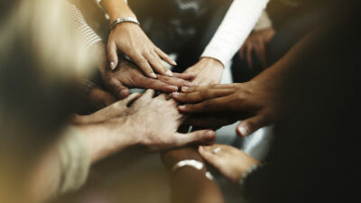 A closeup of diverse people joining their hands in a huddle