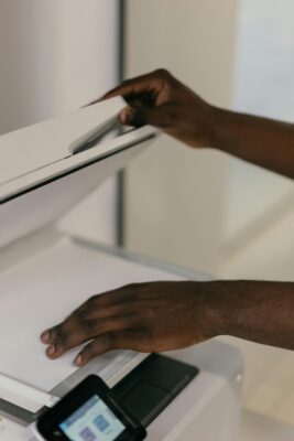 Hands scanning a piece of paper in a machine